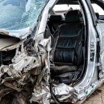 Stark beschädigtes Auto nach schwerem Unfall am Straßenrand mit deformierter Front